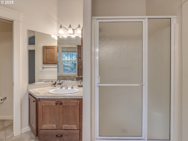 bathroom featuring tile patterned floors, baseboards, vanity, and a shower stall