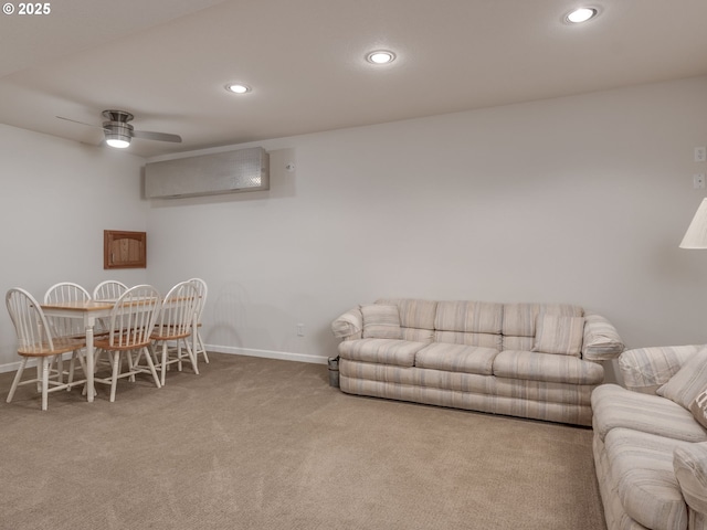 carpeted living area featuring a ceiling fan, baseboards, recessed lighting, and a wall mounted air conditioner