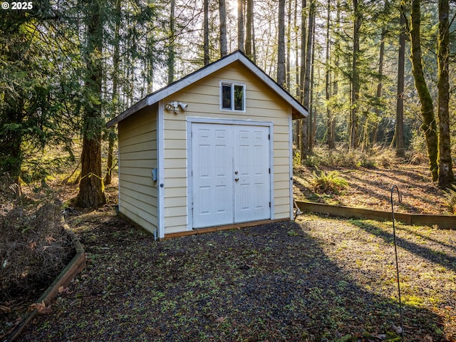 view of shed featuring a view of trees