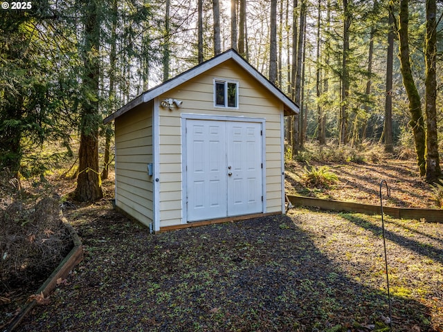 view of shed featuring a view of trees