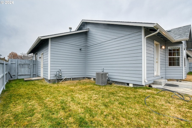 view of side of home featuring a lawn and cooling unit