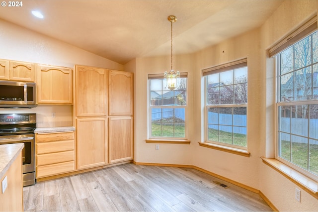 kitchen featuring light brown cabinets, light hardwood / wood-style floors, hanging light fixtures, and appliances with stainless steel finishes