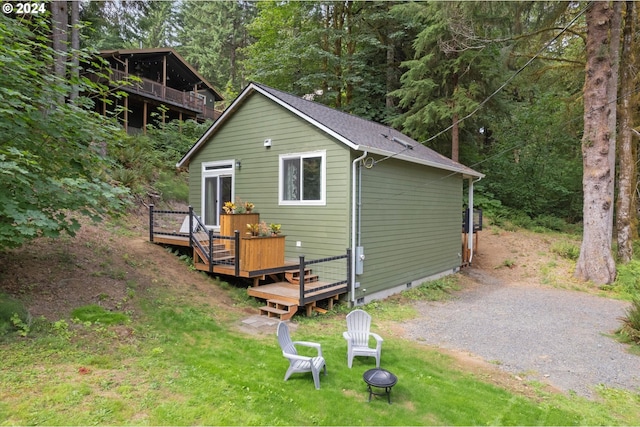 view of outdoor structure with a fire pit and gravel driveway