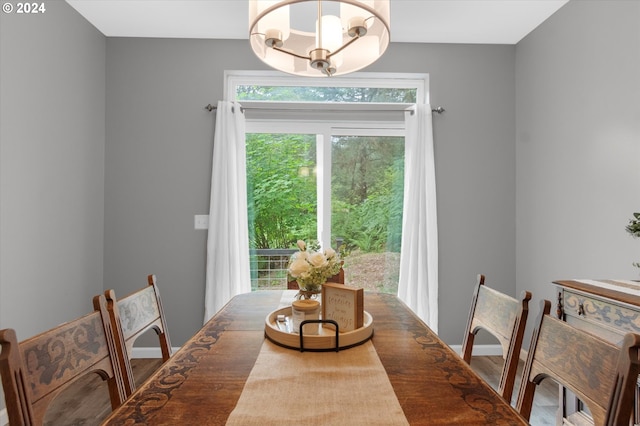 dining space featuring baseboards, a notable chandelier, and wood finished floors