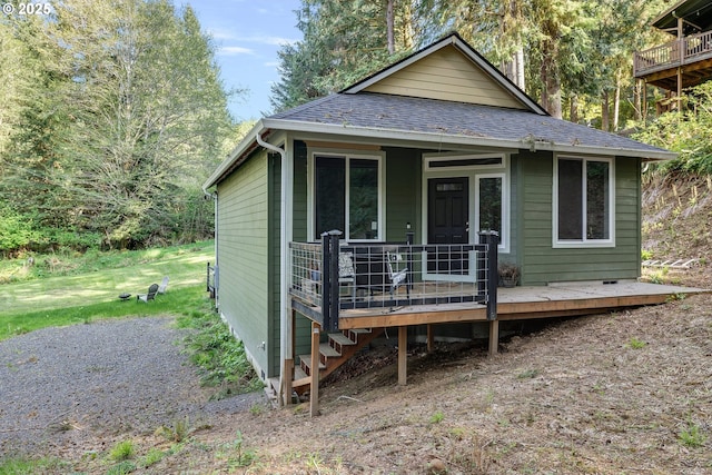 view of front of home with a shingled roof and a deck