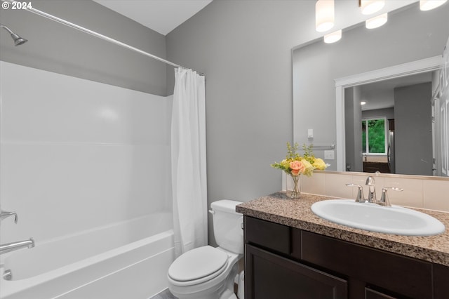 full bathroom featuring toilet, shower / bath combo with shower curtain, and vanity