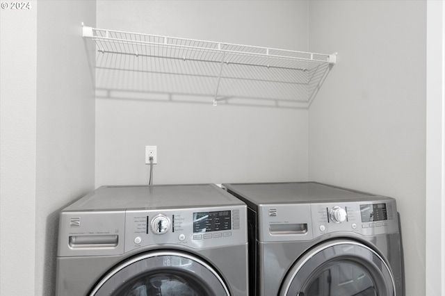 clothes washing area featuring separate washer and dryer