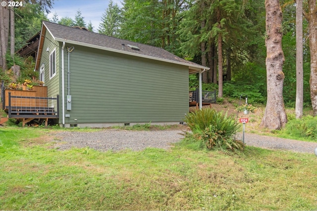 view of home's exterior featuring crawl space, roof with shingles, driveway, and a lawn