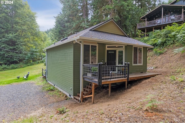 view of outbuilding with covered porch and a forest view