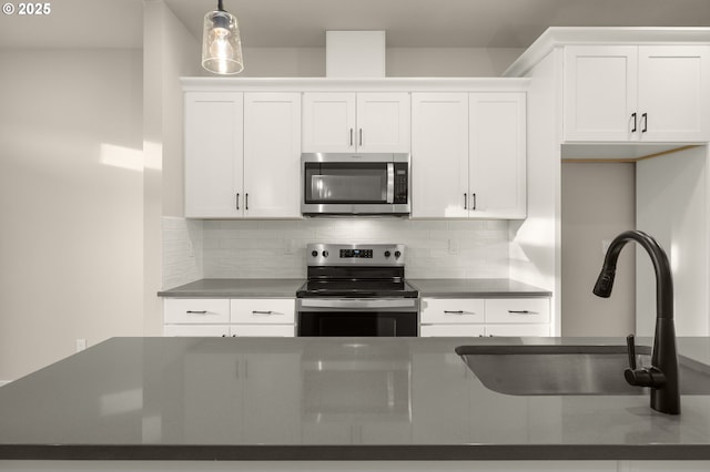 kitchen featuring dark countertops, appliances with stainless steel finishes, and a sink