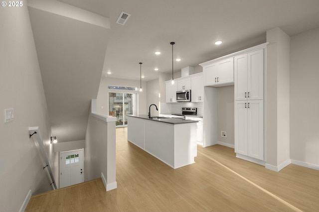 kitchen featuring stainless steel appliances, visible vents, light wood-style flooring, and white cabinetry