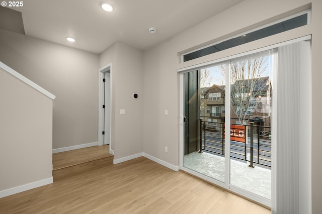 doorway featuring recessed lighting, baseboards, and wood finished floors