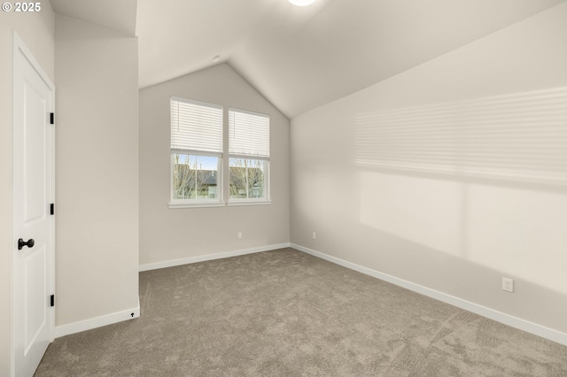 interior space featuring lofted ceiling, baseboards, and carpet floors