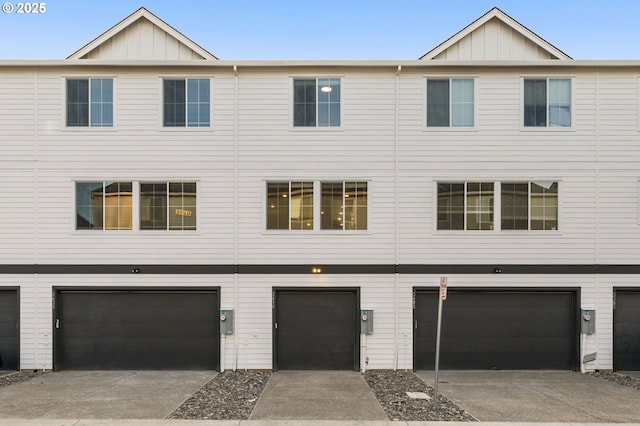 multi unit property featuring board and batten siding, concrete driveway, and an attached garage