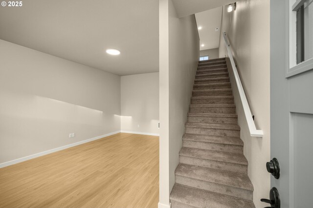 staircase featuring recessed lighting, baseboards, and wood finished floors