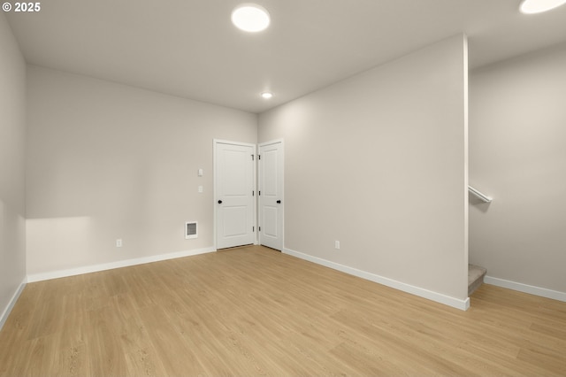 spare room with stairway, baseboards, visible vents, light wood-style flooring, and recessed lighting