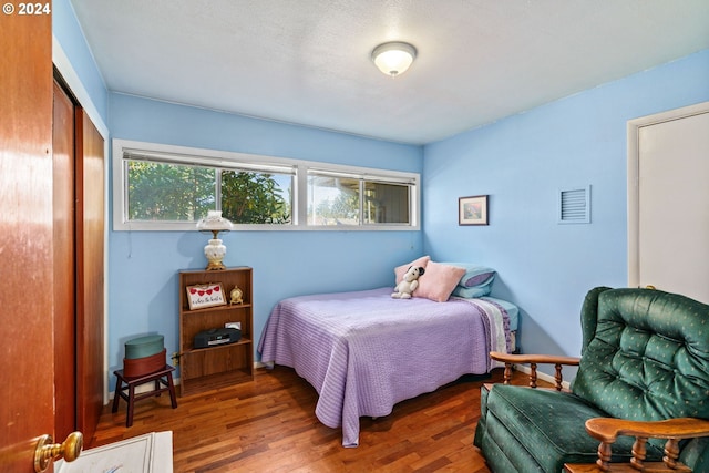 bedroom featuring dark hardwood / wood-style flooring and a closet