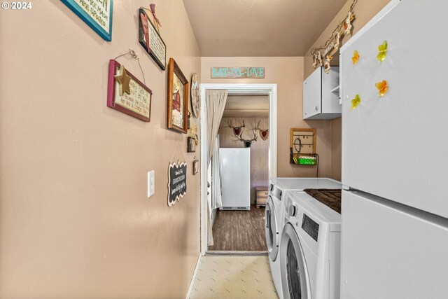 washroom with cabinets and washer and dryer