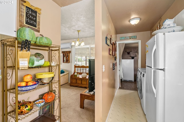 kitchen with refrigerator, a chandelier, hanging light fixtures, white fridge, and washer and clothes dryer