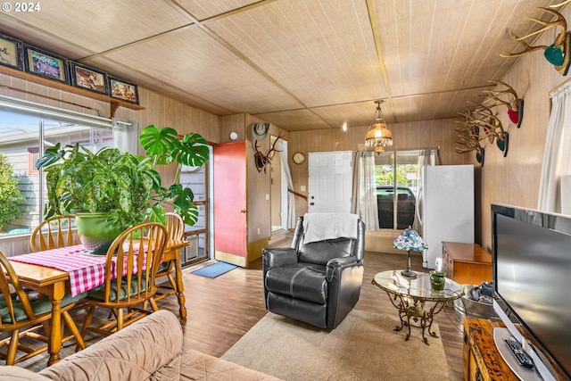 living room featuring wooden walls, hardwood / wood-style floors, and wood ceiling