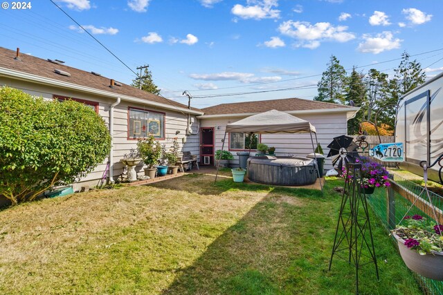 rear view of house featuring a gazebo and a lawn