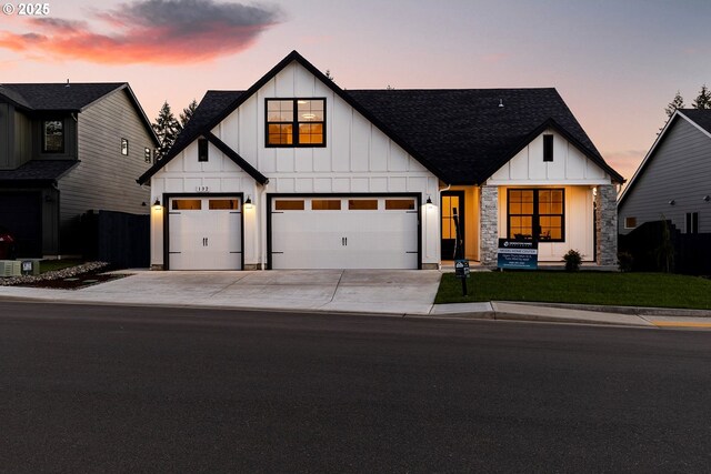 modern inspired farmhouse featuring a front lawn and a garage