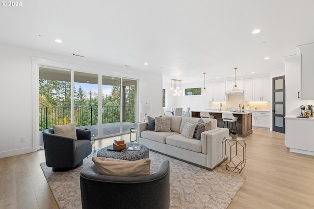 living room featuring light wood-type flooring and sink