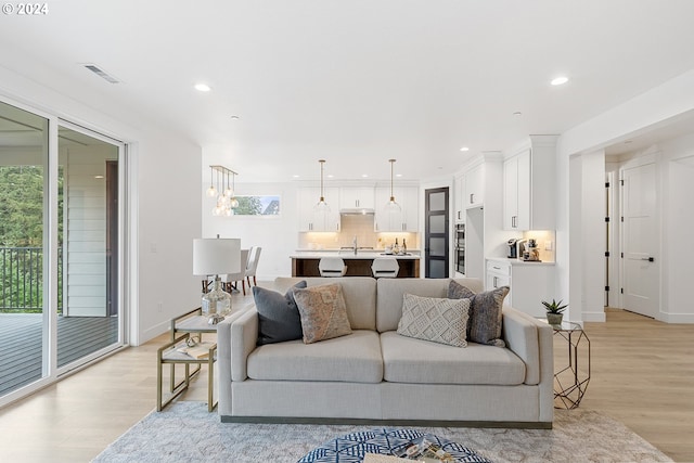 living room featuring light wood-type flooring and sink