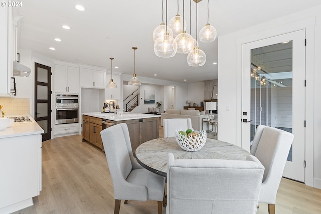 dining space featuring light wood-type flooring and sink