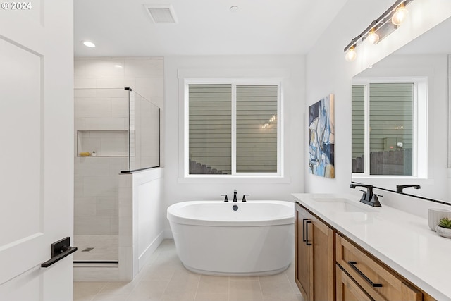 bathroom with tile patterned floors, vanity, and plus walk in shower