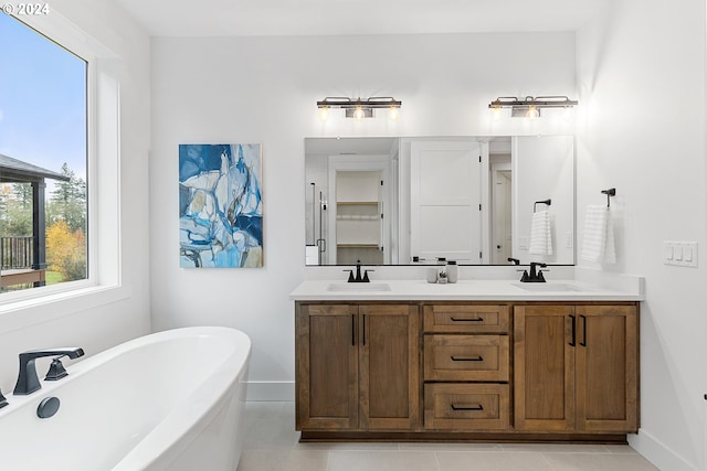 bathroom featuring tile patterned flooring, a bathtub, and vanity