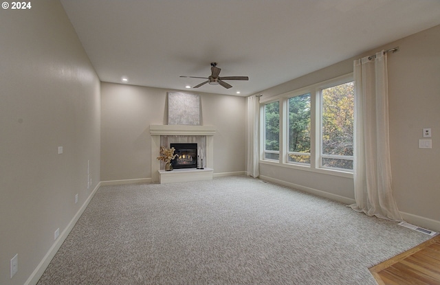 unfurnished living room featuring ceiling fan and carpet