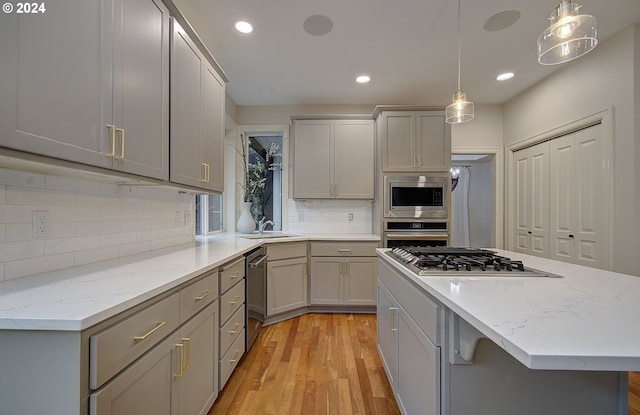 kitchen with gray cabinets, light hardwood / wood-style flooring, and pendant lighting