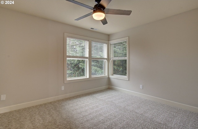 carpeted spare room featuring ceiling fan