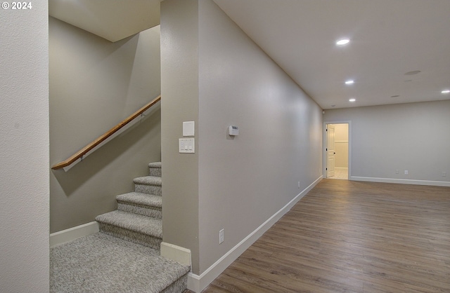 stairs featuring hardwood / wood-style floors