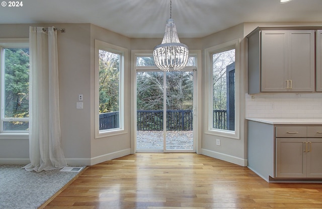 unfurnished dining area with light hardwood / wood-style flooring and a chandelier