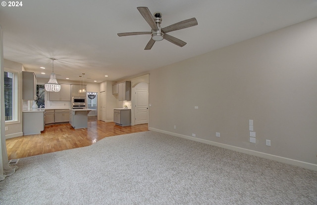 unfurnished living room with ceiling fan and light hardwood / wood-style floors