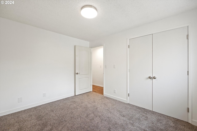 unfurnished bedroom featuring a closet, a textured ceiling, and carpet floors