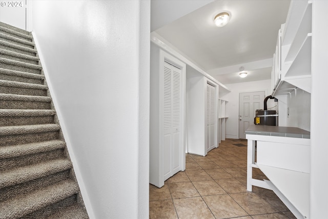 hallway with light tile patterned flooring and water heater