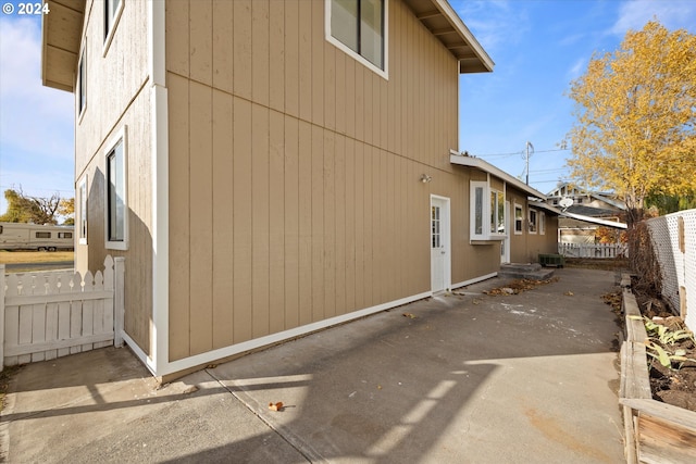 view of side of property with a patio and central air condition unit