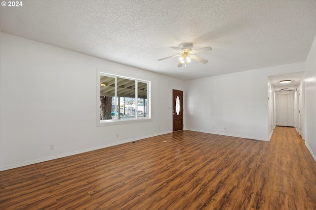 spare room featuring dark wood-type flooring, ceiling fan, and a textured ceiling