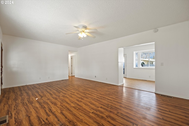 empty room with a textured ceiling, dark hardwood / wood-style floors, and ceiling fan