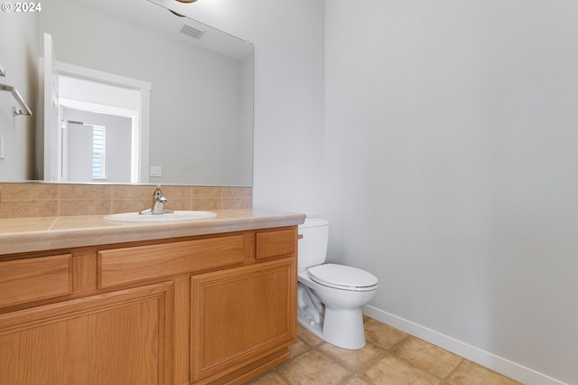 bathroom with vanity, toilet, and tile patterned floors