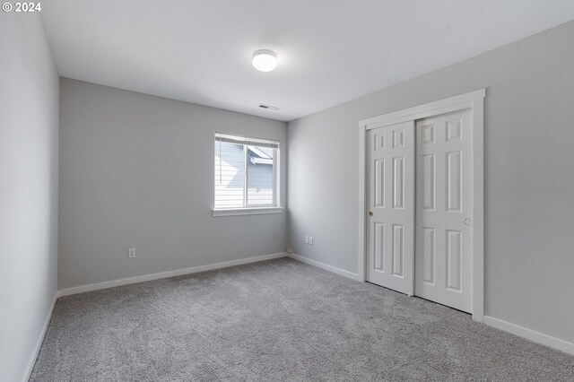 unfurnished bedroom with a closet and carpet