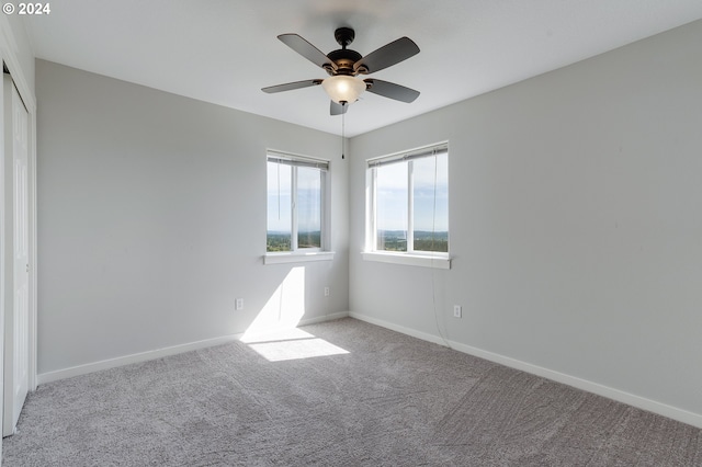 unfurnished room featuring light colored carpet and ceiling fan