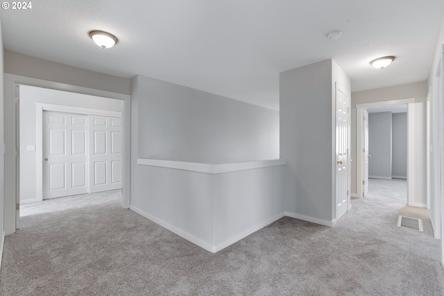 hall with light colored carpet