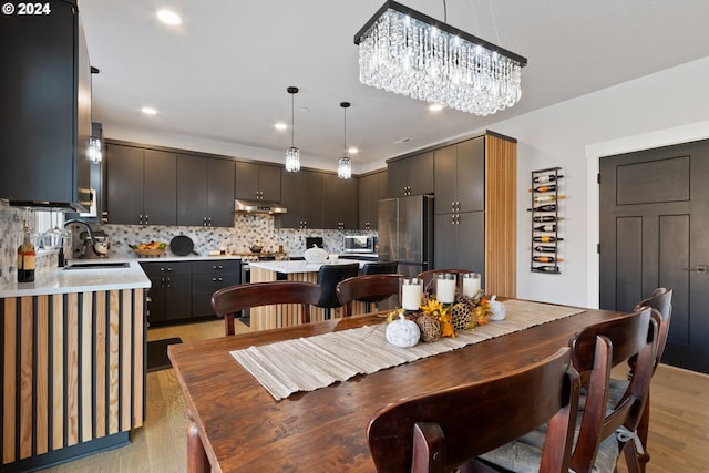 dining room with a chandelier, light hardwood / wood-style floors, and sink