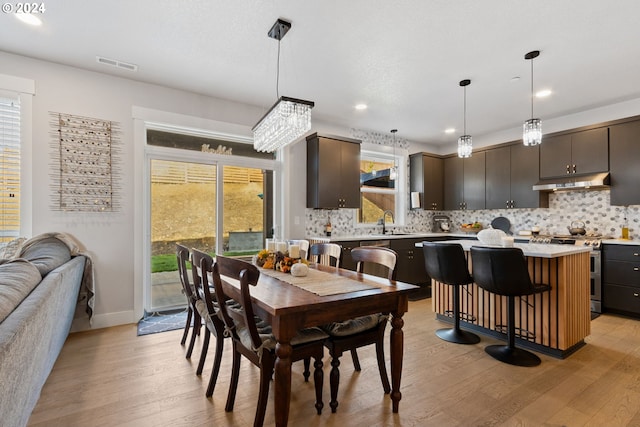 dining space with sink and light hardwood / wood-style flooring