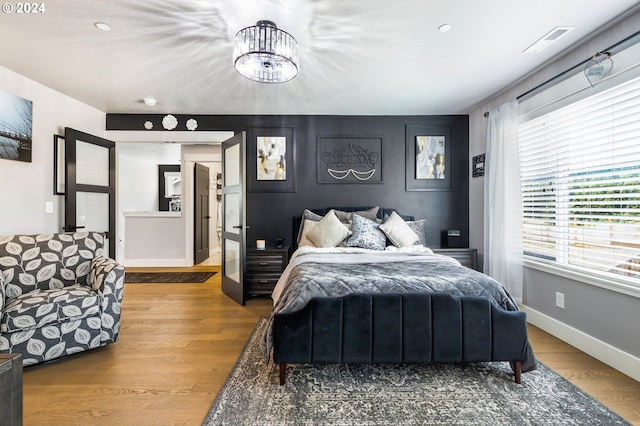 bedroom featuring wood-type flooring and an inviting chandelier