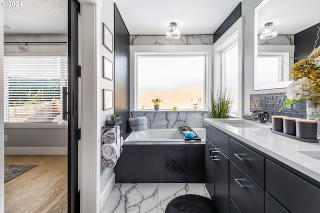 bathroom with hardwood / wood-style flooring, plenty of natural light, and a bath